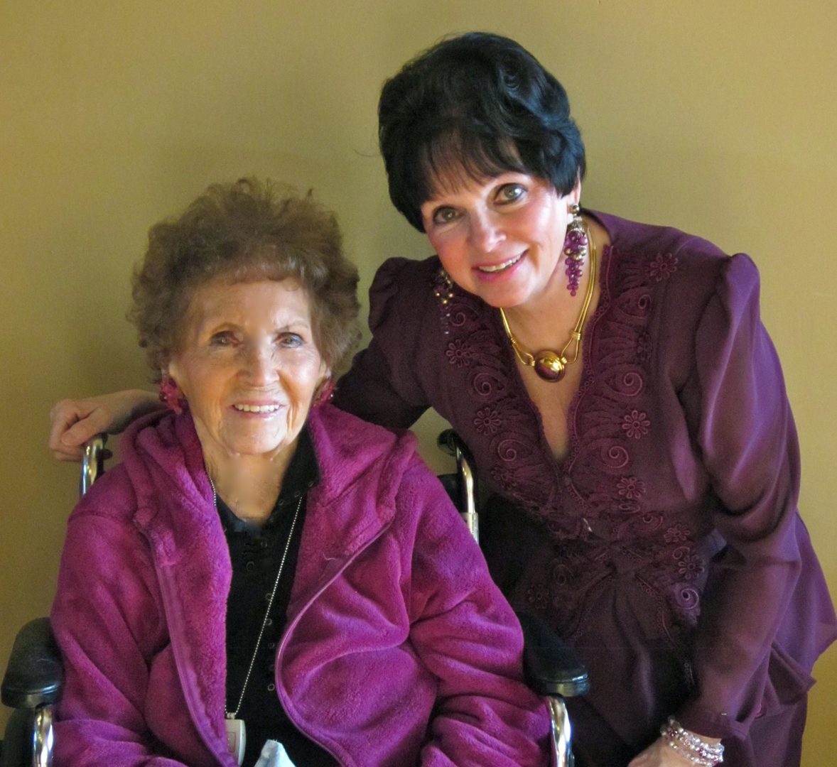 Two women smiling, one in a wheelchair.