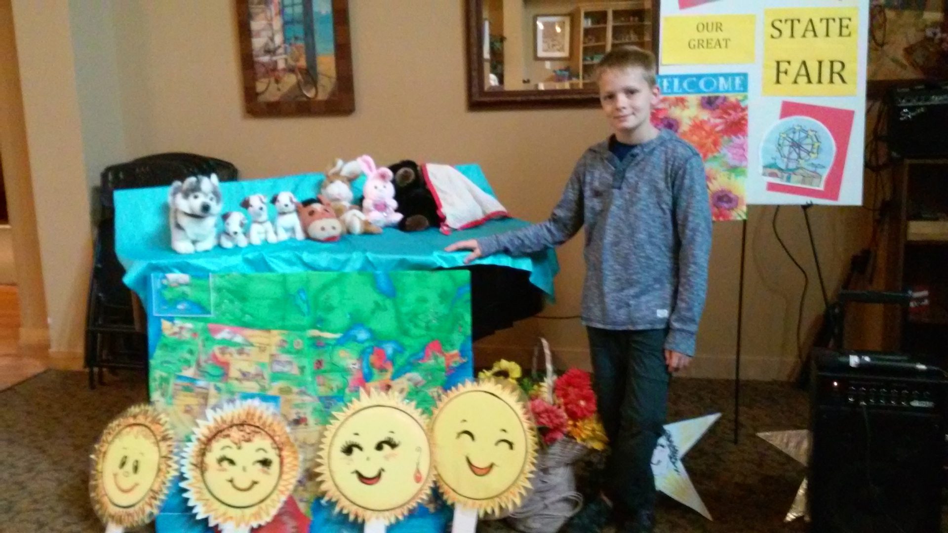Boy standing by colorful fair display table.