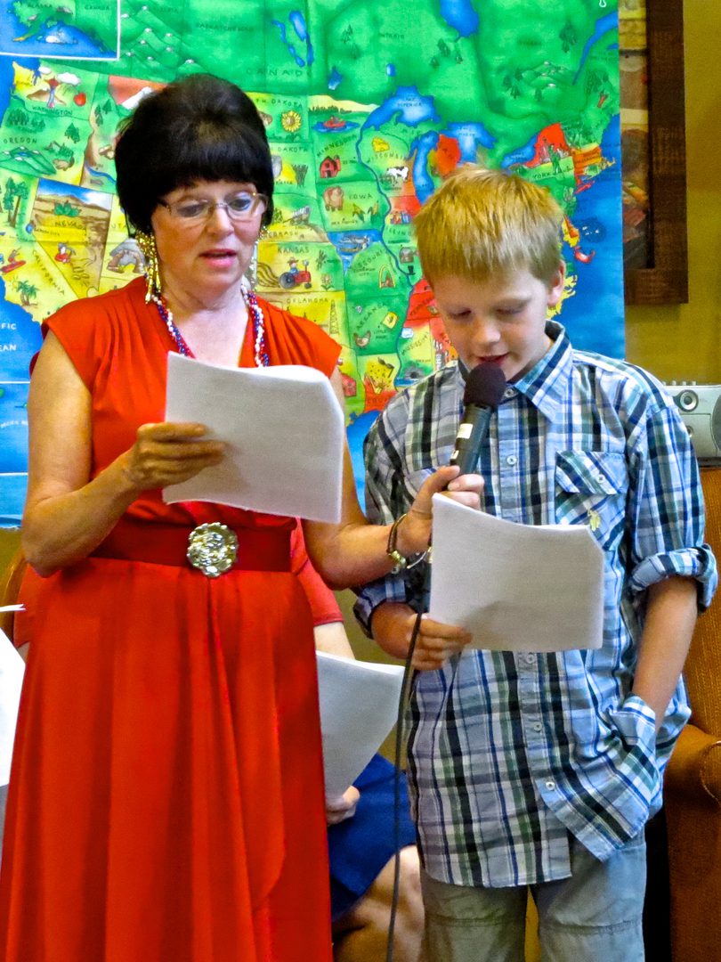 Woman and boy reading from papers together.