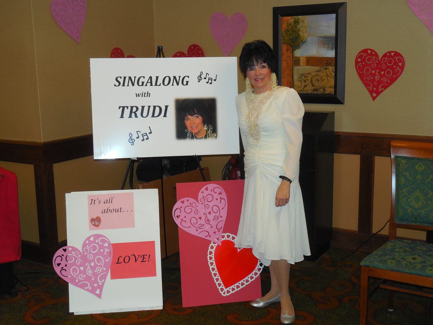 Woman standing by singing event sign.