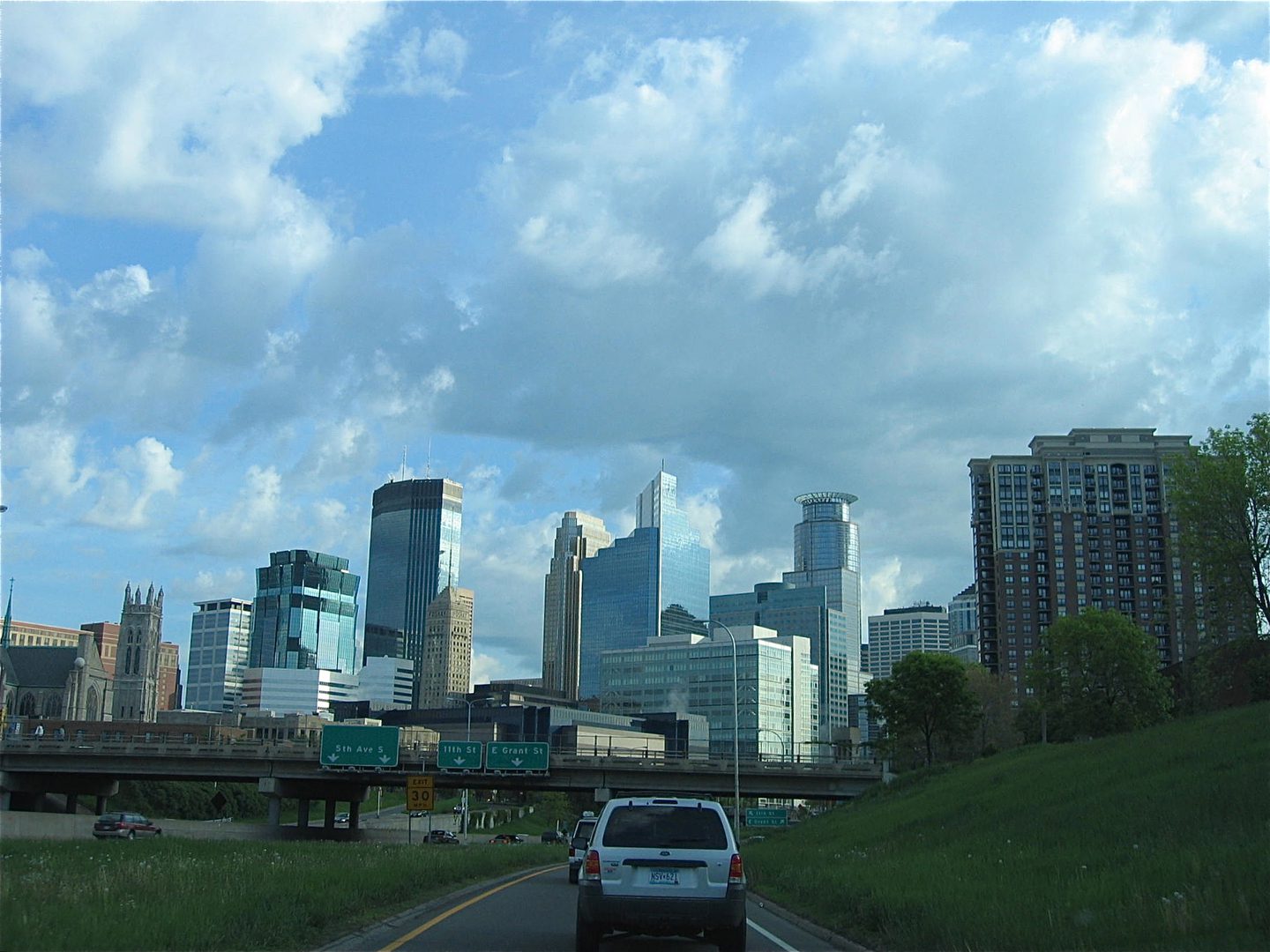 City skyline with cloudy blue sky.