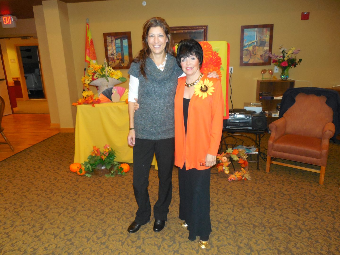 Two women posing in decorated room.