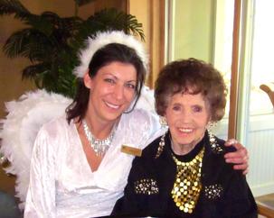 Woman dressed as angel with elderly woman.